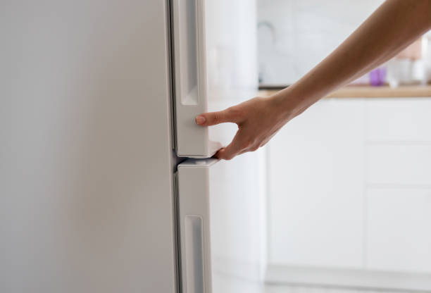 istock hand is opening refrigerator door 1516016682