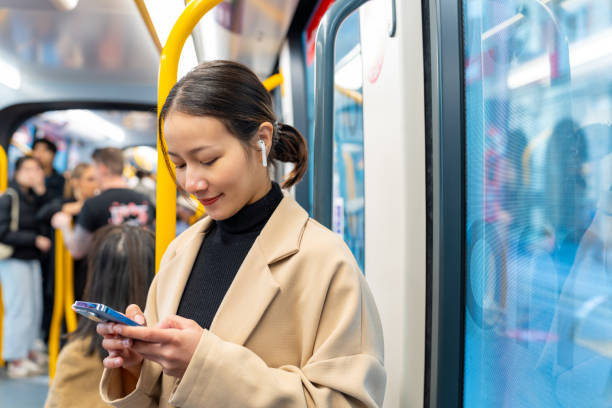 istock Asian woman using mobile phone on train 1516054439