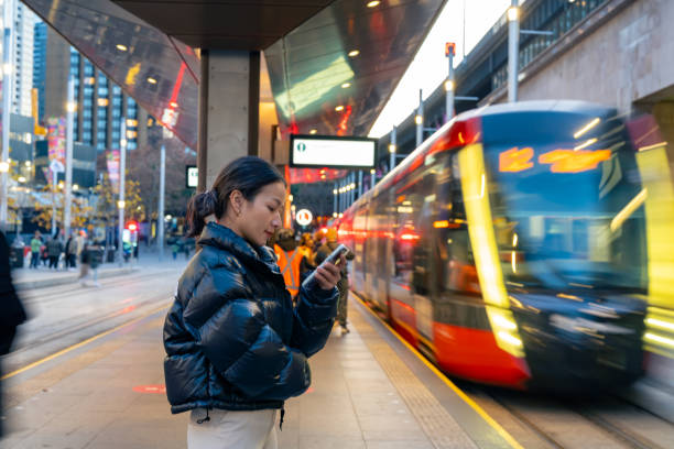 istock Asian woman using mobile phone during waiting for train at railway station. 1516055460