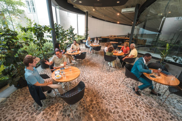 istock Diverse Group Relishing Coffee and Hot Drinks in a Modern Cafeteria 1516105280