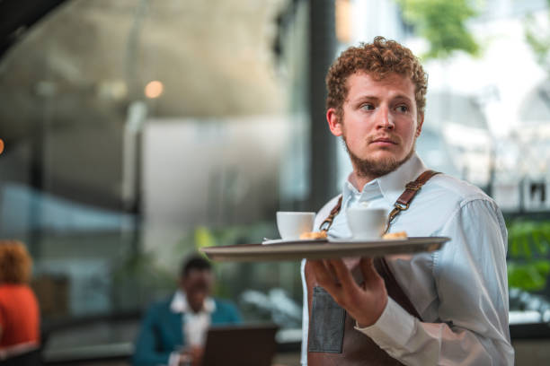 istock Polished Caucasian Waiter Serves Artisan Coffee in Modern Cafe Setting 1516105281