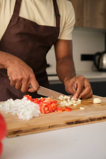istock Unrecognizable young african man cutting garlic. 1516105291