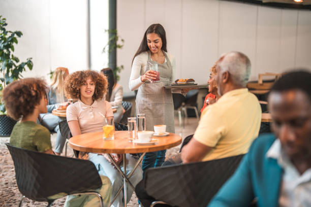 istock Skilled Hispanic Waitress Serving a Multi-Generational Family with Care in a Modern Cafe 1516105337