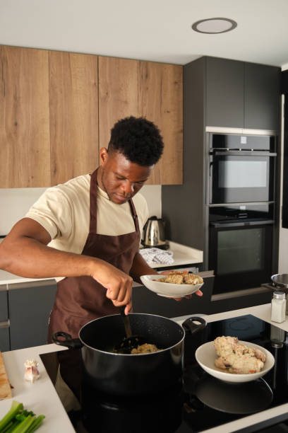istock Young black man preparing fried chicken mince with vegetables recipe. 1516108580