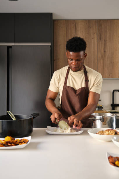 istock Young black man serving rice on a plate. 1516109713