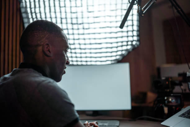 Handsome Male Musician Using Acoustic Guitar And Recording Vocals In Studio