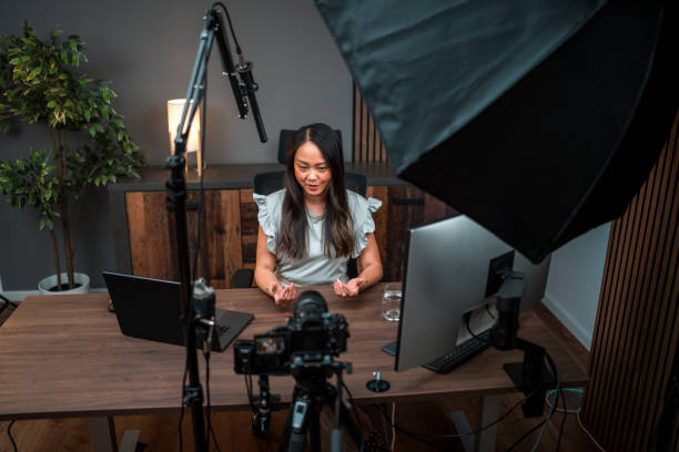 istock Focused Asian Female Content Creator Talking to Camera 1516112523