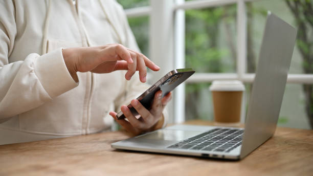 istock Cropped image of a female using her smartphone while remote working at a coffee shop. 1516117017