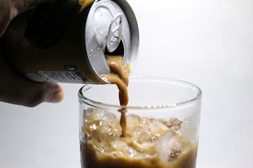 Pouring canned coffee into a glass