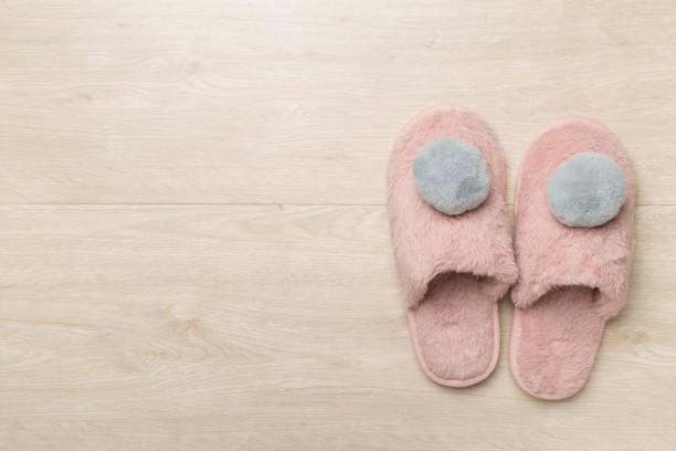 istock Soft pink slippers on wooden background, top view 1516165864