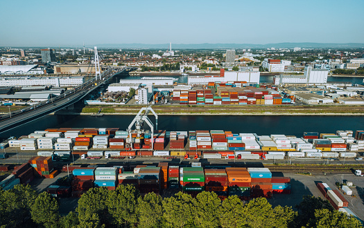 Aerial view of cargo containers, stacked cargo containers \nBetween Mannheim and Ludwigshafen in Baden Wurttemberg, Neckar river, Germany