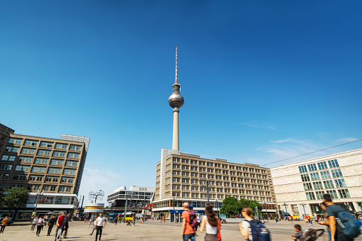 Iconic Alexanderplatz subway station: bustling hub, vibrant streets, modern urban atmosphere, with TV Tower and yellow tram.