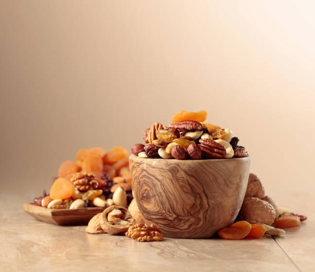 istock Dried fruits and nuts on a beige ceramic table. 1516174377