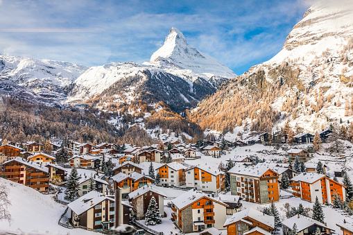 Zermatt, Switzerland - November 12, 2019: Aerial view of snowcapped village with background of iconic mountain peak Matterhorn, some hotels are closed in winter.