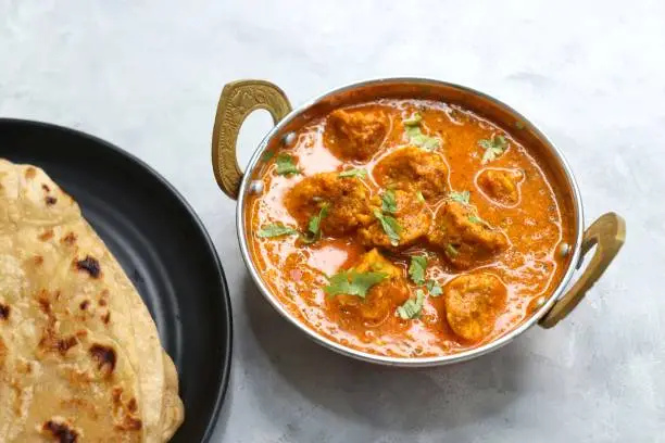 Photo of Rajasthani Gatta Curry or Besan Ke Gatte Ki Sabzi. Gatte are gram flour roundels or chickpea flour dumplings are cooked in a spicy, tangy yogurt based curry. delicacy of Rajasthan, India. copy space.