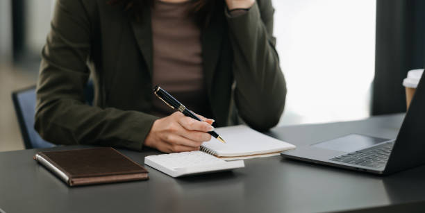 istock businesswoman hand working with new modern computer and writing on the notepad strategy diagram as concept morning light 1516206597