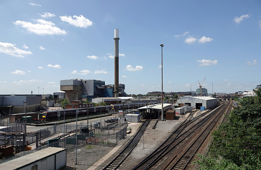 Nottingham, UK - July 16, 2021: An East Midlands Railway train in the sidings and the Eastcroft Incinerator waste burning facility  in the background in the city of Nottingham, UK.