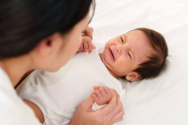 istock mother with newborn baby crying on bed 1516216242