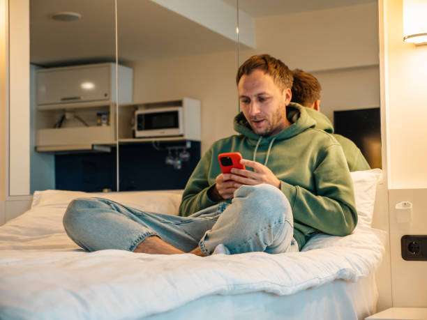 istock Smiling man using social media and browsing internet holding mobile phone at home 1516259264