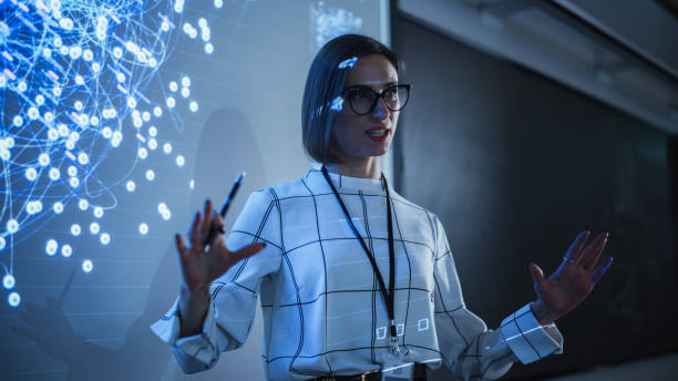 istock Young Businesswoman Giving a Data Science Presentation in a Dark Auditorium with Projecting Slideshow with Artificial Intelligence Neural Network Architecture. Business Startup and Education Concept 1516275128