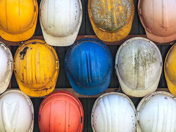 Old used construction helmets Old and worn colorful construction helmets hard hat stock pictures, royalty-free photos & images