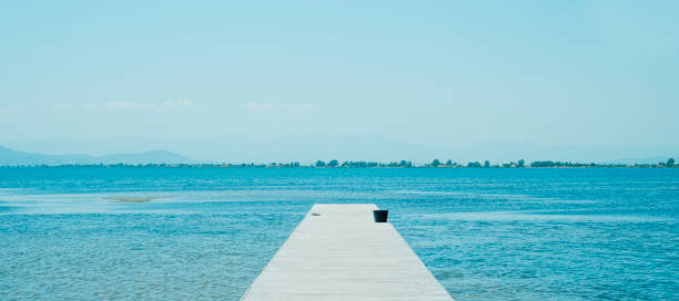 istock lonely wooden pier on a summer day, banner 1516329239