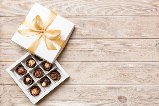 White box with chocolates candies and golden tape. top view with copy space.