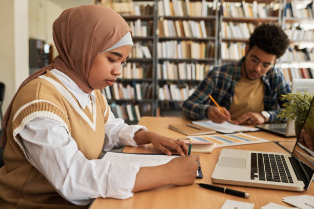istock Muslim girl writing exam in class 1516345367