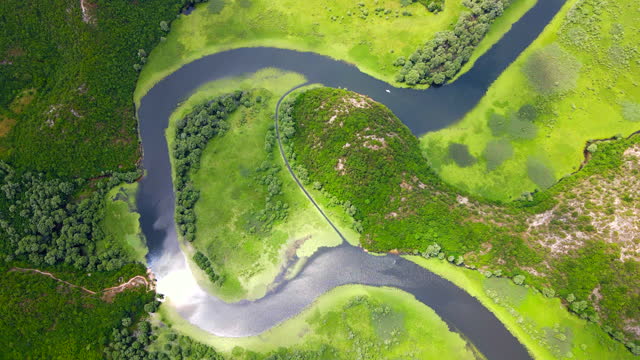 Aerial footage captures the stunning view of the horseshoe-shaped river bend at Pavlova Strana near Skadar lake in Montenegro. The footage provides a mesmerizing view of the natural beauty of Montenegro, giving a sense of peacefulness and serenity.