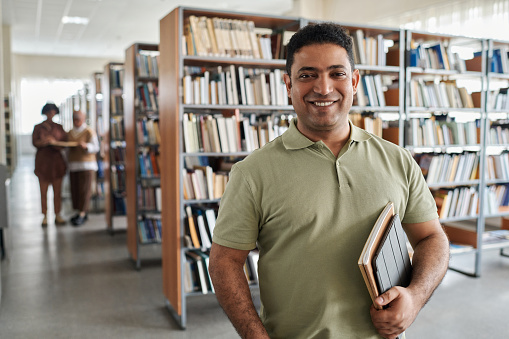 Estudiante adulto de pie en la biblioteca photo