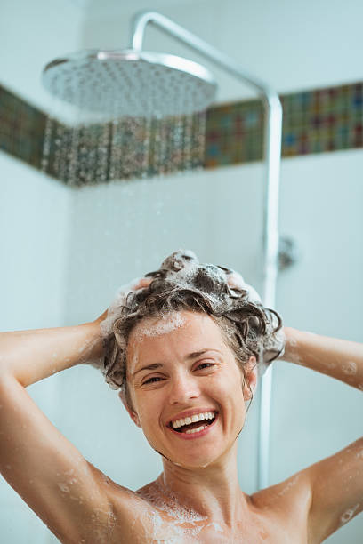 istock Happy woman applying shampoo in shower 151635312