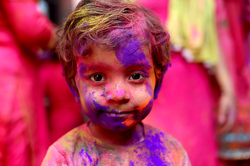 4-5 years baby girl celebrating Holi festival. Holi is a popular and significant Hindu festival celebrated as the Festival of Colours, Love and Spring. It celebrates the eternal and divine love of the god Radha and Krishna.