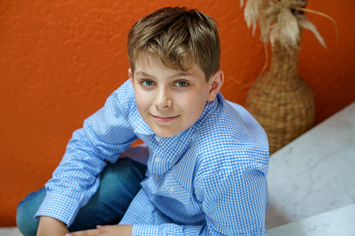 Handsome Teenager Boy Poses Indoors, Exuding Confidence and Style in a Captivating Portrait. Happy Preteen Child
