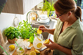 Hispanic woman preparing fresh lemonade in kitchen