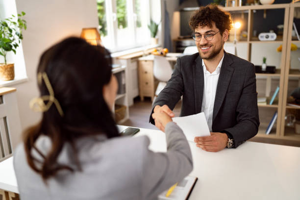 Male candidate handshake with an female recruiter Young Caucasian man handshake with a female recruiter/HR of Japanese ethnicity during job interview good cv stock pictures, royalty-free photos & images