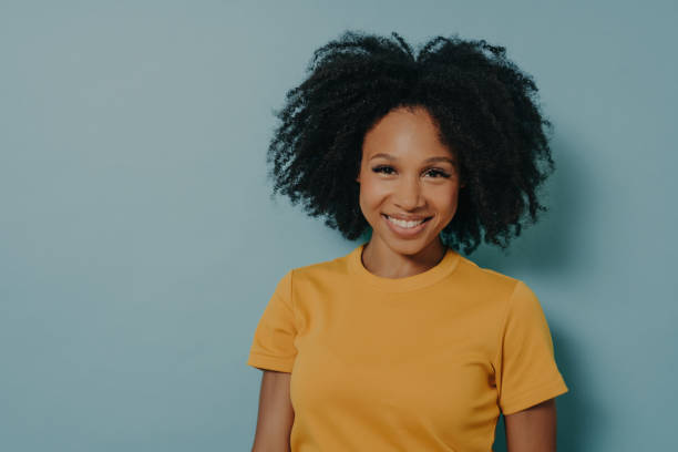 istock Happy dark skinned woman smiling at camera with pleased face expression, isolated on blue background 1516385458