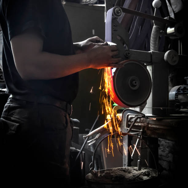 istock Male grinding a knife in a forge workshop with flying sparks 1516406155