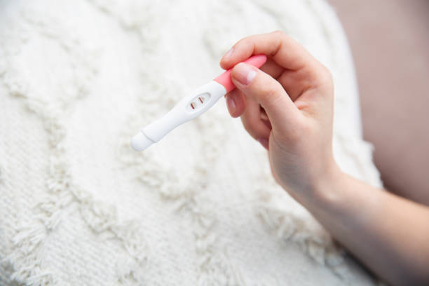 Woman holds a pregnancy test in her hand with two lines stock photo