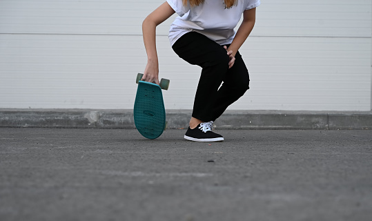 Beautiful and blonde girl practicing long board on the road