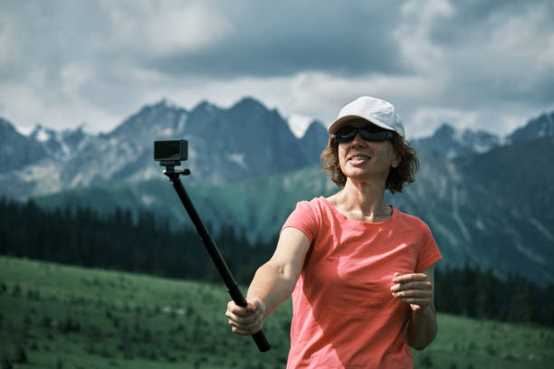 istock Female vlogger is streaming while walking in mountains 1516462389