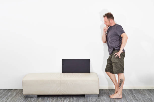 istock Man in shorts holding black sign barefoot 1516462440