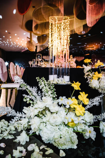 istock Composition flowers, candles, candlesticks on floor hall restaurant. Chairs for guests. Table setting, setup. Trendy decor large chandelier. Birthday, baptism, event. Details golden rich interior. 1516488329