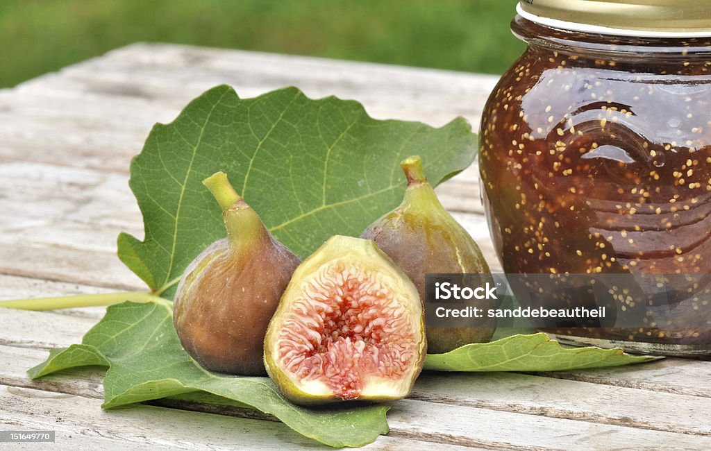 figues and jam pot figs on a fig leaf next to a jam pot Bisected Stock Photo