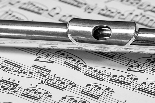 Silver flute head on a music score.\n\nNovember 2018