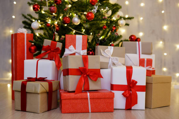 istock heap of gift boxes under decorated christmas tree over grey wall with festive led lights 1516547103