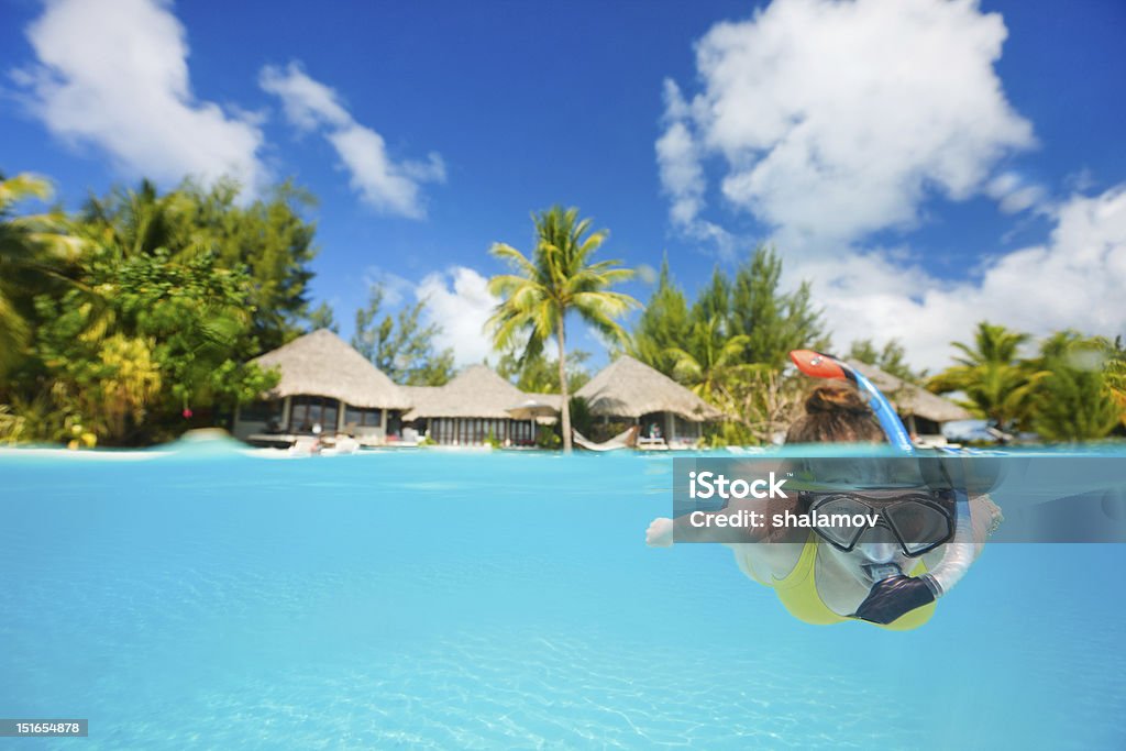 Woman snorkeling Woman snorkeling in clear tropical waters in front of exotic island Bora Bora Stock Photo