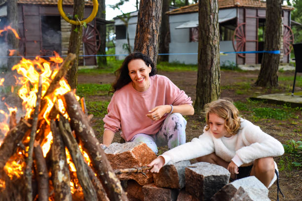 istock Mother with her little daughter spending time together, kindle a fire and throw sticks 1516549233
