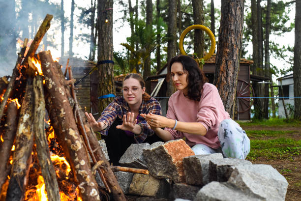 istock Mother with her daughter spending time together, kindle a fire and throw sticks 1516549256