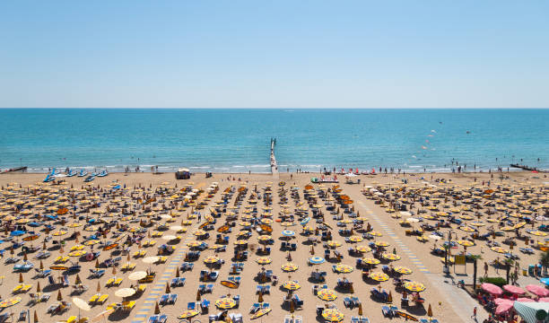 Wonderful capture of venetian beach on a sunny afternoon. Jesolo, Caorle, Lignano, Rimini, Bibione Beach, they are looking quite the same. All human faces and brands are well blurred and not recognizable, so you can use it for commercial purposes. Cyan blue ocean and light blue sky. Well post-processing.