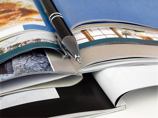 istock Magazines open and stacked with a pen 151655110